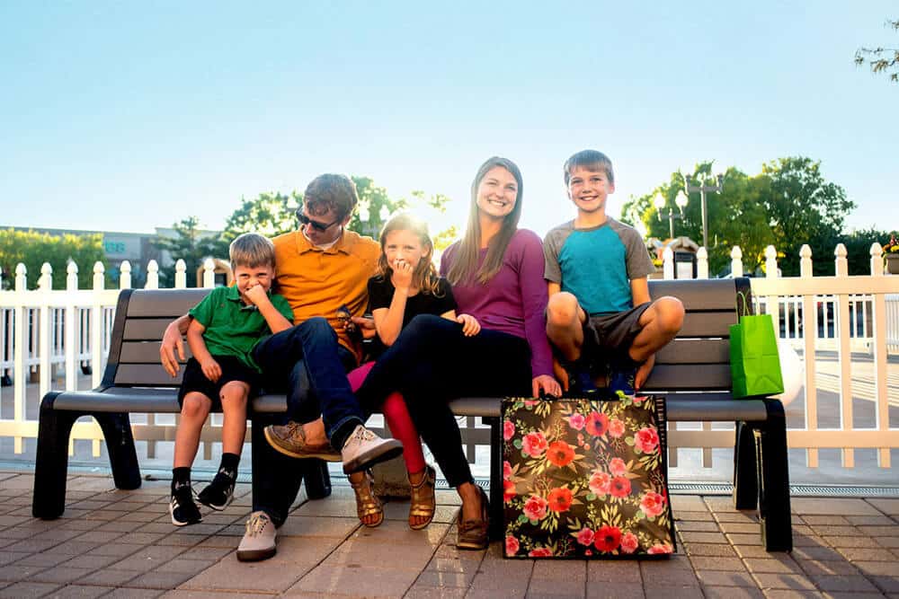 A family on a bench enjoying the First and Main Town Center