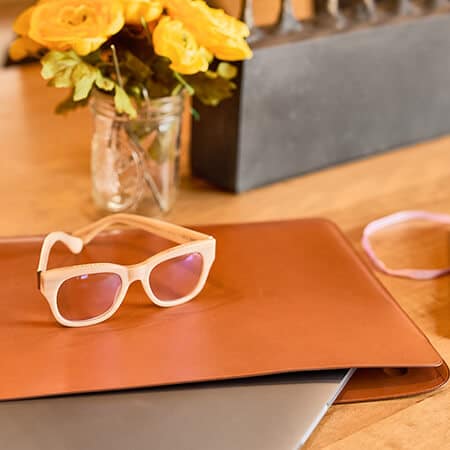 warm textured wood and leather, yellow flowers and tan glasses