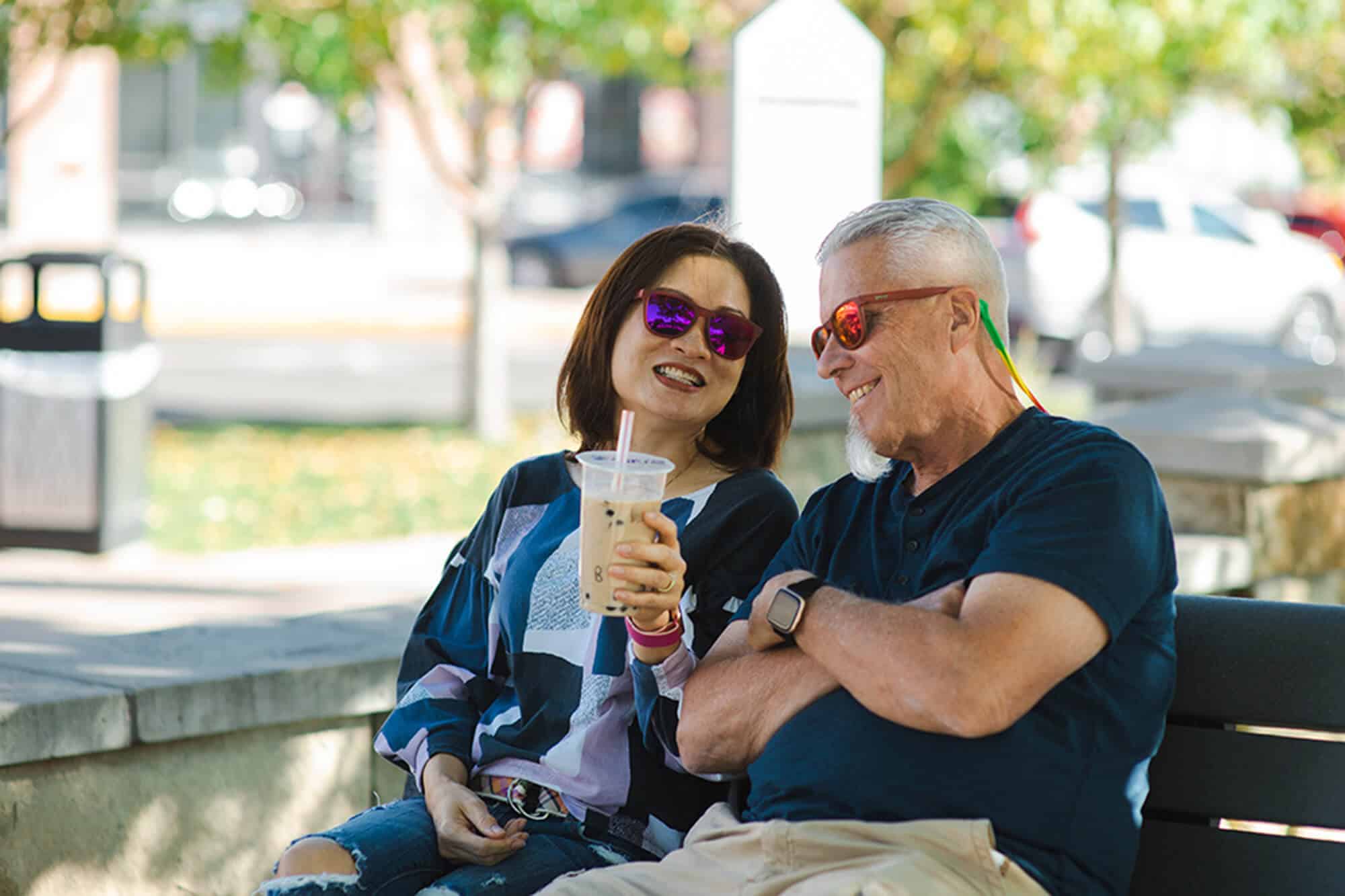 A couple sitting on a bench in the neighborhood